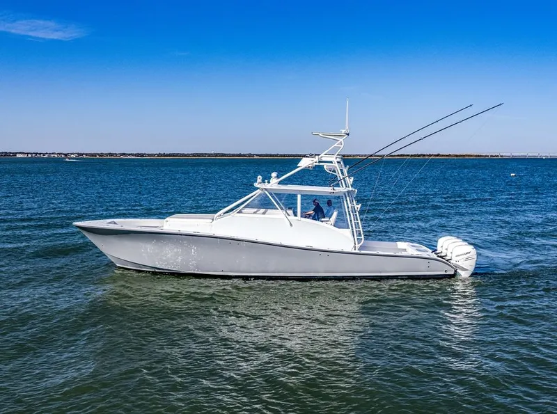 Slide: The Image of 2021 Conch 47 boat cruising on open water under clear blue sky. - 12