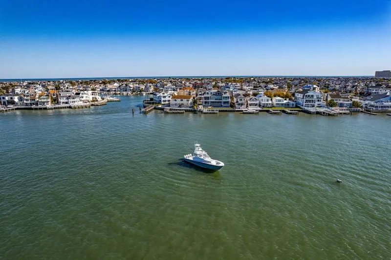 Slide: The Image of Aerial view of a 2021 Conch 47 boat on a calm bay near coastal houses. - 13