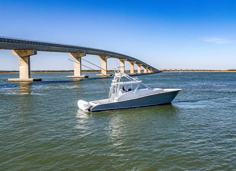 Slide: The Image of 2021 Conch 47 boat cruising under a bridge on a sunny day. - 14