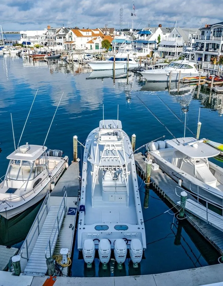 Slide: The Image of A 2021 Conch 47 boat docked in a marina with surrounding yachts. - 18