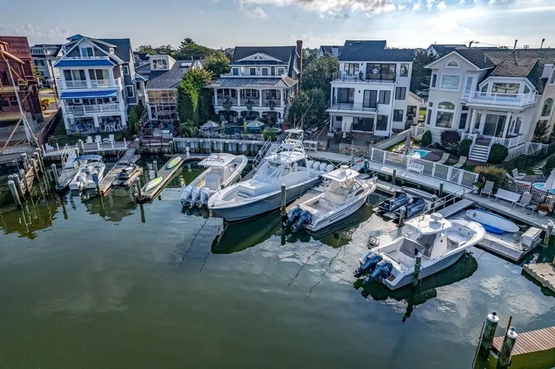 Slide: The Image of Waterfront homes with docked Conch 47 boats, 2021 model, in a serene marina setting. - 22