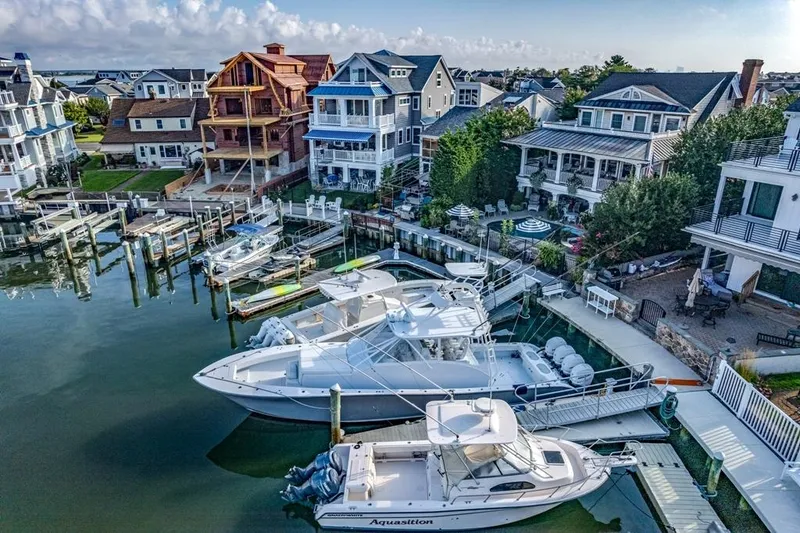 Slide: The Image of Aerial view of luxury boats docked near waterfront homes, featuring a 2021 Conch 47 model. - 23