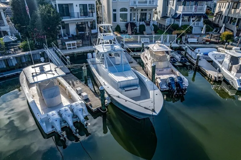 Slide: The Image of 2021 Conch 47 boat docked in a marina, surrounded by other boats and waterfront homes. - 27