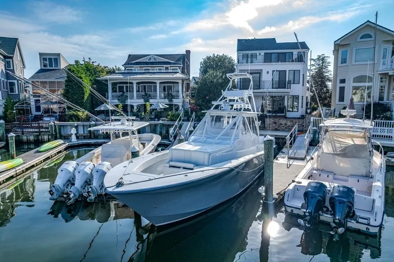 Slide: The Image of 2021 Conch 47 boat docked in a scenic marina with waterfront homes. - 28