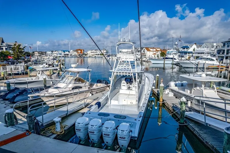 Slide: The Image of A 2021 Conch 47 boat docked in a vibrant marina under a clear blue sky. - 30