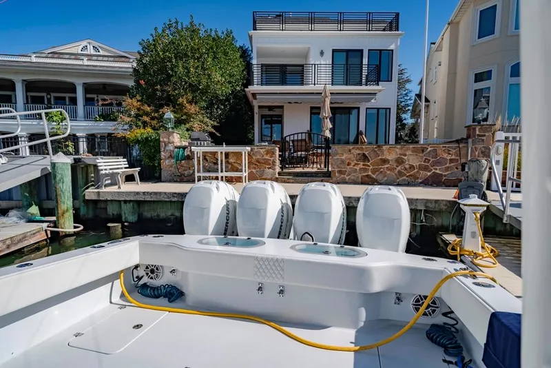 Slide: The Image of Conch 47 boat docked near waterfront homes, showcasing four powerful engines, 2021 model. - 32