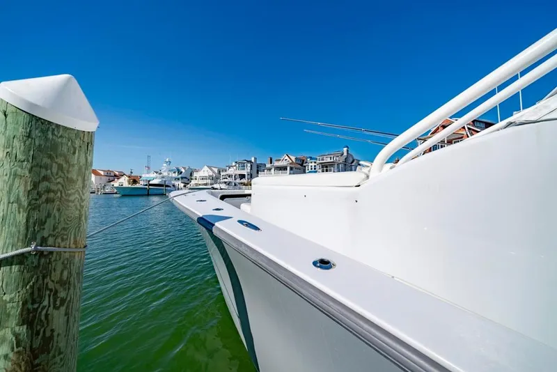 Slide: The Image of Conch 47 boat docked in marina, clear blue sky, 2021 model. - 35