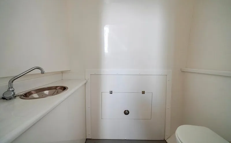 Slide: The Image of Compact bathroom interior in a 2021 Conch 47 model, featuring a sink and toilet. - 42