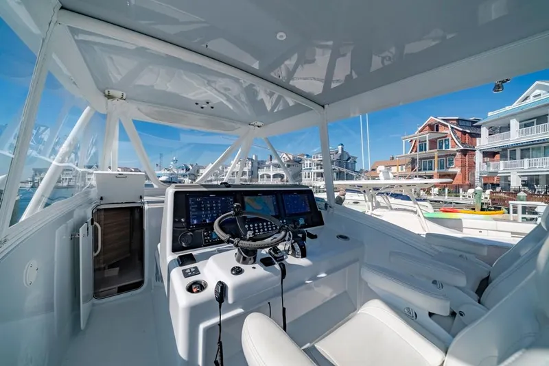 Slide: The Image of Interior view of 2021 Conch 47 boat with modern dashboard and waterfront background. - 45