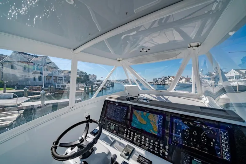 Slide: The Image of Interior view of 2021 Conch 47 boat cockpit with navigation screens and steering wheel. - 47