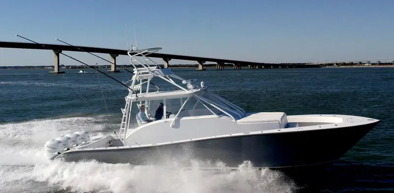 Slide: The Image of 2021 Conch 47 boat cruising on water near a bridge. - 5