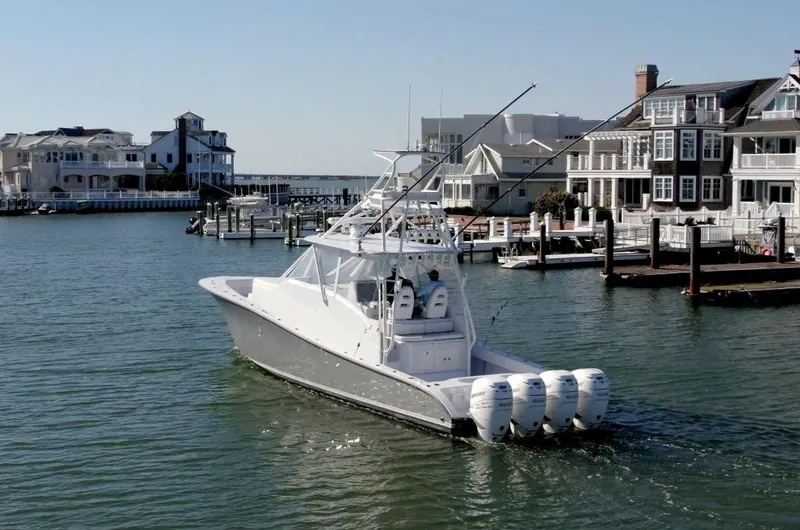 Slide: The Image of Conch 47 boat, 2021 model, cruising near waterfront homes and docks. - 8