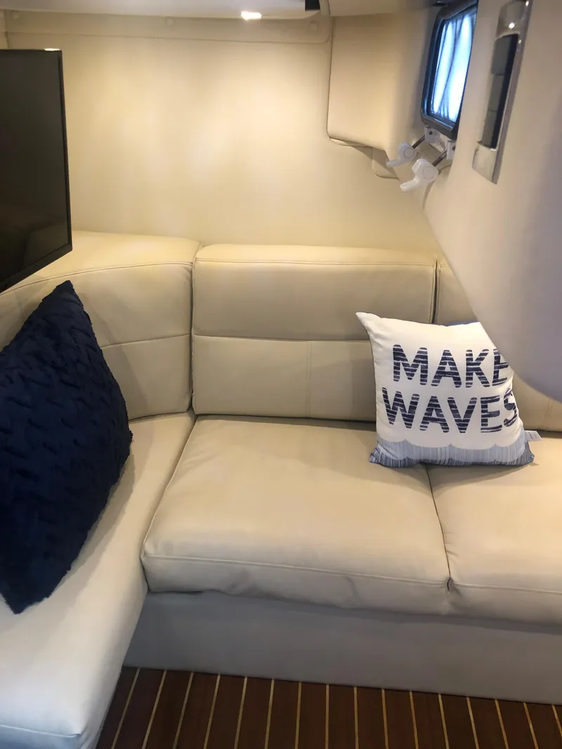 Slide: The Image of 2007 Rinker 350 Express Cruiser interior with beige seating and decorative pillows. - 10