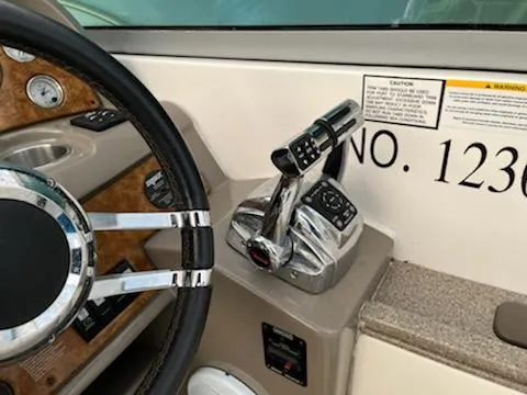 Slide: The Image of 2007 Rinker 350 Express Cruiser helm with steering wheel and throttle controls. - 16