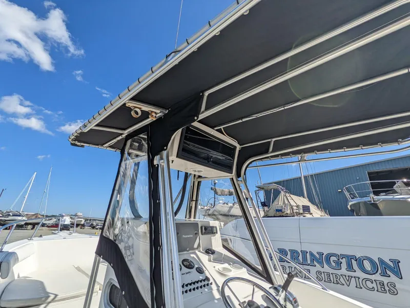 Slide: The Image of 2007 Sea Boss 235 Center Console boat with T-top, docked under clear blue sky. - 18