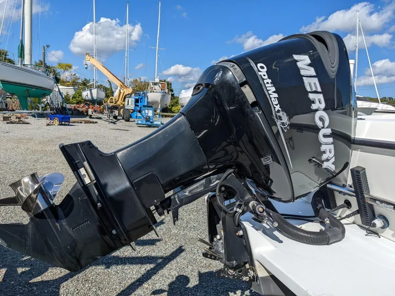 Slide: The Image of Mercury OptiMax outboard motor on 2007 Sea Boss 235 Center Console boat, in a boatyard setting. - 4