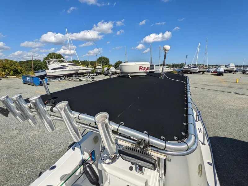 Slide: The Image of 2007 Sea Boss 235 Center Console boat with radar, docked in a marina under a clear sky. - 9