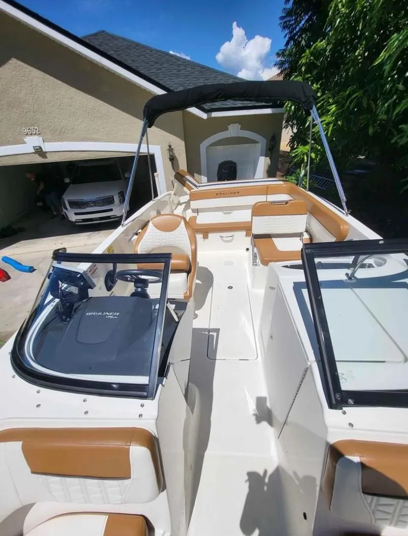 Slide: The Image of 2021 Bayliner VR6 Bowrider OB boat with tan and white interior, parked in driveway. - 12