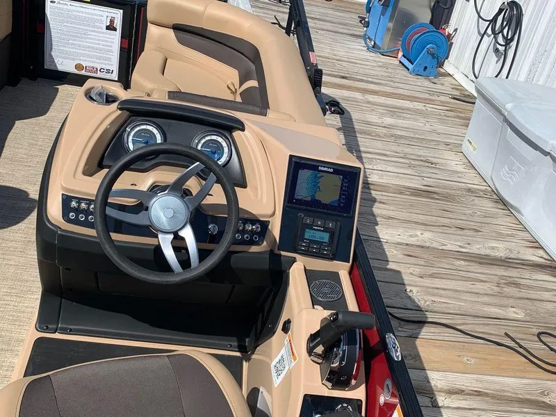 Slide: The Image of 2023 Barletta Cabrio 24UE boat dashboard with steering wheel and navigation system. - 11
