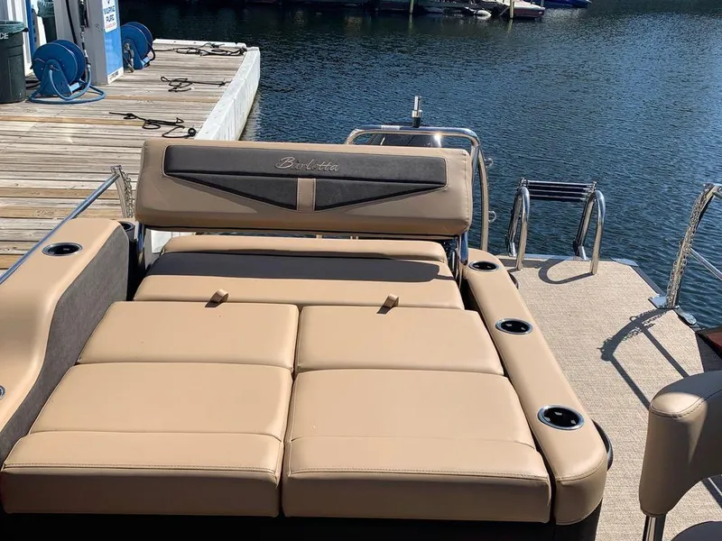 Slide: The Image of 2023 Barletta Cabrio 24UE pontoon boat with tan seating at dock. - 3