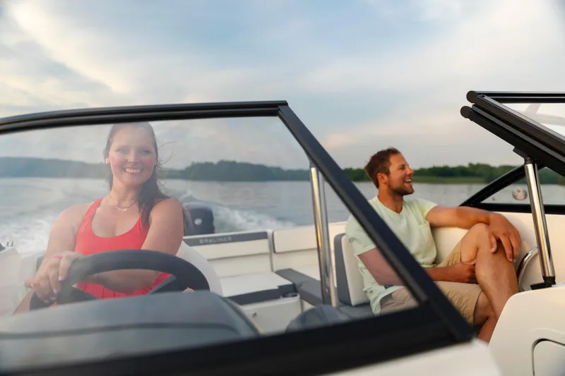 Slide: The Image of 2023 Bayliner VR4 OB boat with two people enjoying a ride on the water. - 2