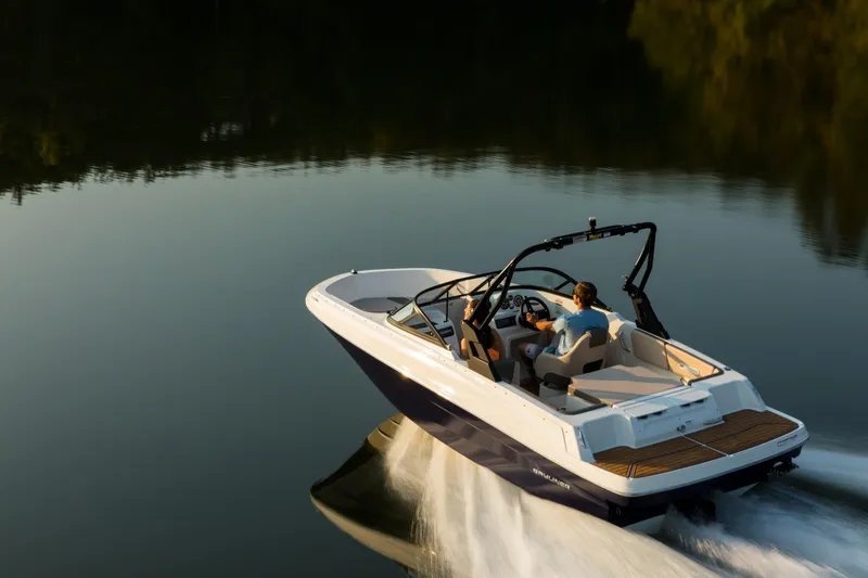 Slide: The Image of 2023 Bayliner VR4 OB boat cruising on calm water at sunset. - 23