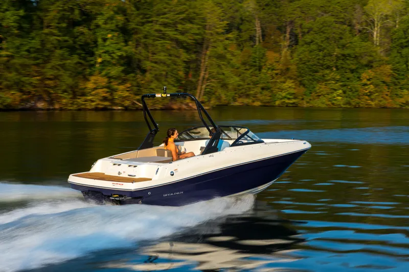 Slide: The Image of 2023 Bayliner VR4 OB speedboat cruising on a serene lake with lush green trees. - 25