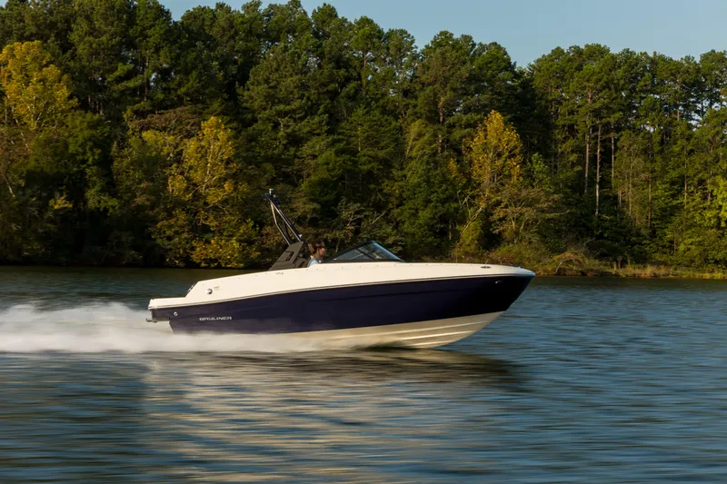 Slide: The Image of 2023 Bayliner VR4 OB speedboat cruising on a serene lake with lush forest backdrop. - 26