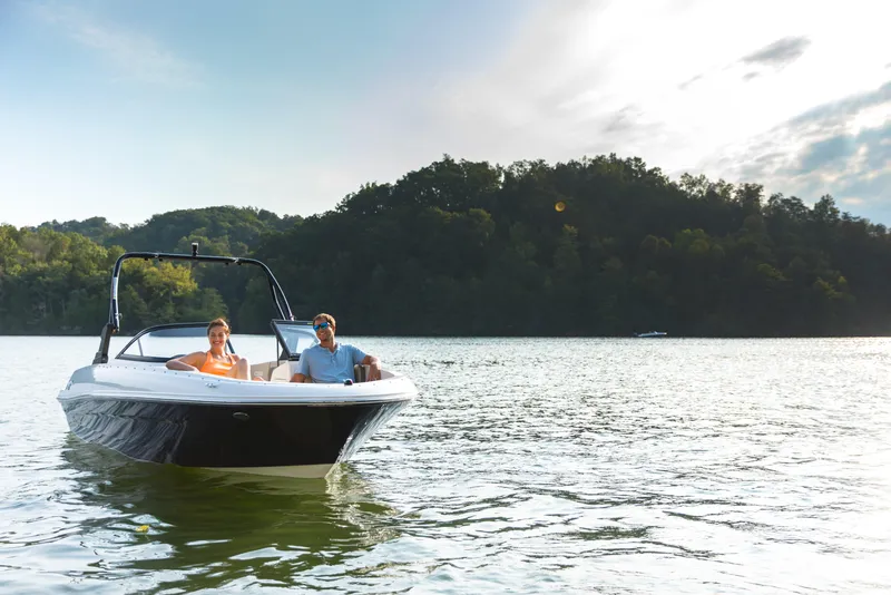 Slide: The Image of 2023 Bayliner VR4 OB boat cruising on a scenic lake with two passengers. - 30