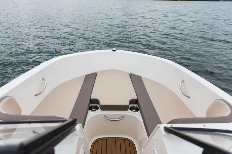 Slide: The Image of 2023 Bayliner VR4 OB boat interior with cushioned seating, cup holders, and water view. - 31