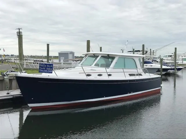 The Image of 2024 Back Cove 372 yacht docked at a marina under cloudy skies. - 0