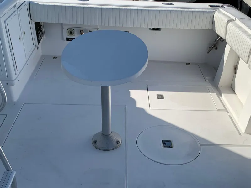 Slide: The Image of 1997 Phoenix 38 SFX Convertible boat deck with round table and seating. - 10