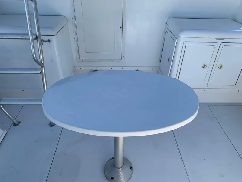 Slide: The Image of Interior of 1997 Phoenix 38 SFX Convertible boat with table and storage cabinets. - 14