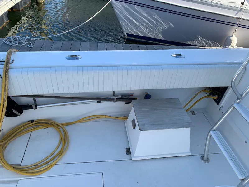 Slide: The Image of 1997 Phoenix 38 SFX Convertible boat deck with coiled yellow hose and dock view. - 16