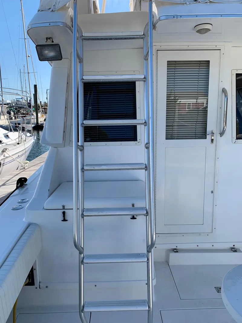 Slide: The Image of 1997 Phoenix 38 SFX Convertible yacht ladder and door, docked at marina. - 17