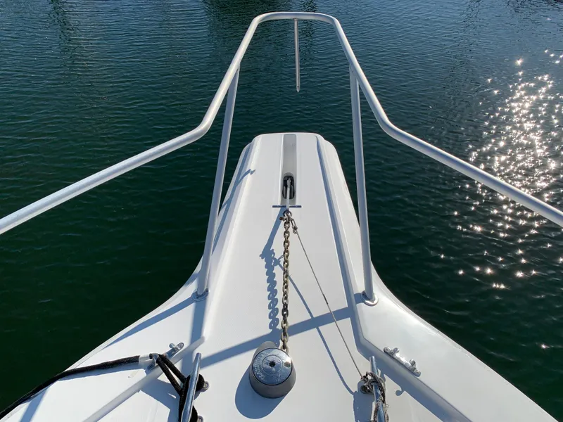 Slide: The Image of Bow of 1997 Phoenix 38 SFX Convertible boat with anchor chain over sparkling water. - 21