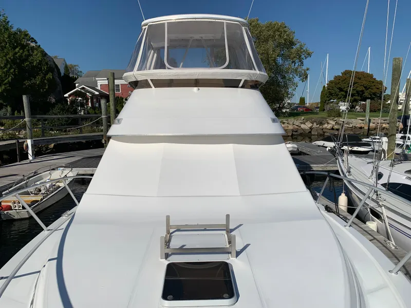 Slide: The Image of 1997 Phoenix 38 SFX Convertible yacht docked at marina, clear sky background. - 22