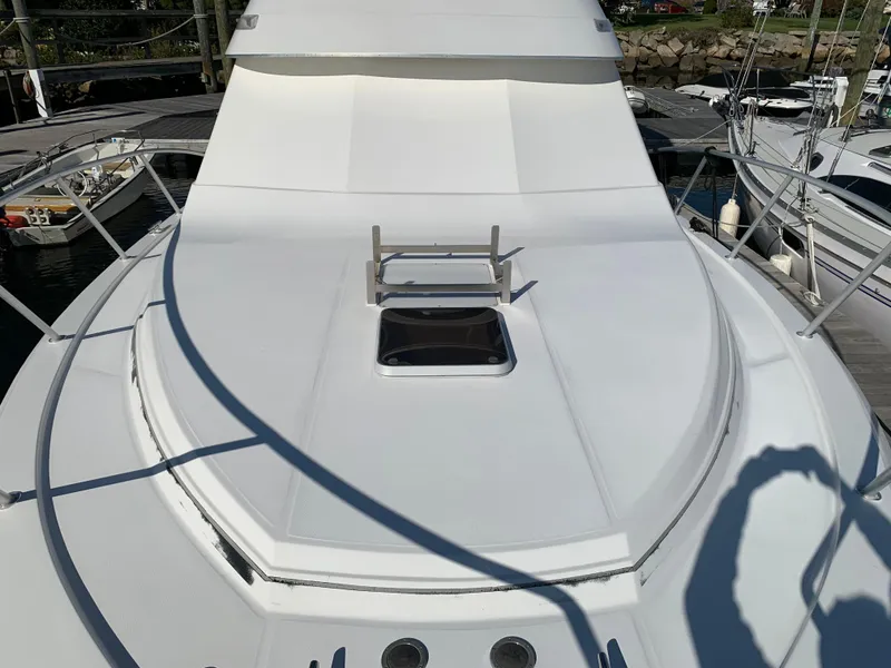 Slide: The Image of 1997 Phoenix 38 SFX Convertible yacht deck with hatch, docked at marina. - 23