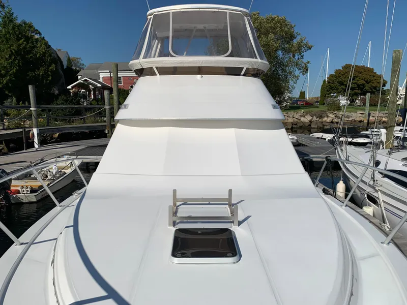 Slide: The Image of 1997 Phoenix 38 SFX Convertible yacht docked at marina, clear sky background. - 24
