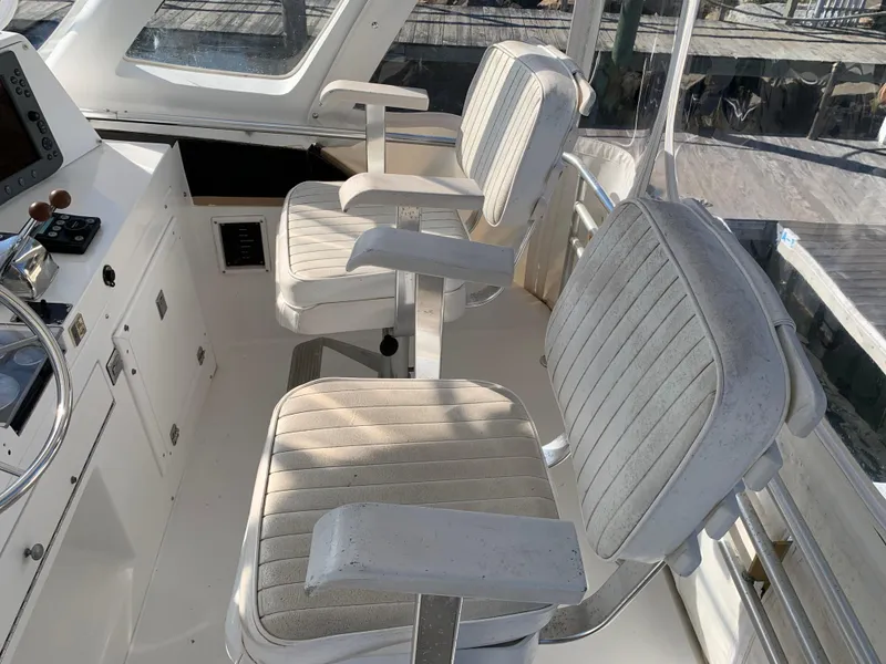 Slide: The Image of Interior of 1997 Phoenix 38 SFX Convertible boat with two cushioned captain chairs. - 29