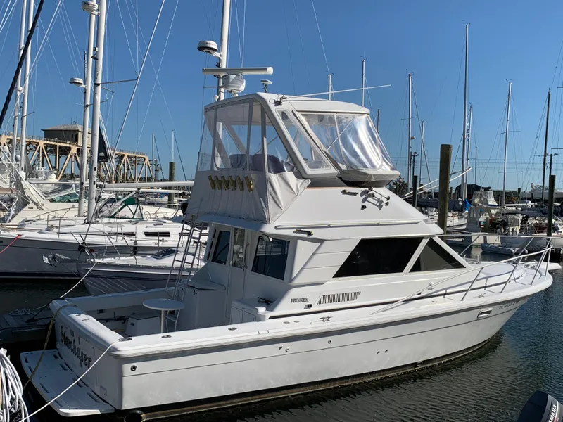 Slide: The Image of 1997 Phoenix 38 SFX Convertible yacht docked in a marina, surrounded by sailboats. - 3