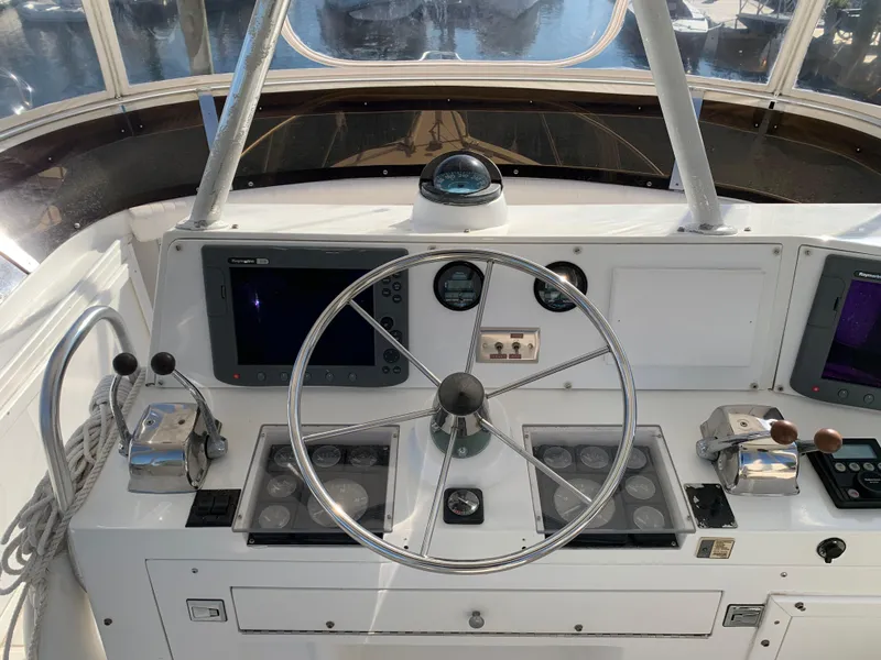 Slide: The Image of 1997 Phoenix 38 SFX Convertible boat helm with steering wheel and navigation controls. - 30