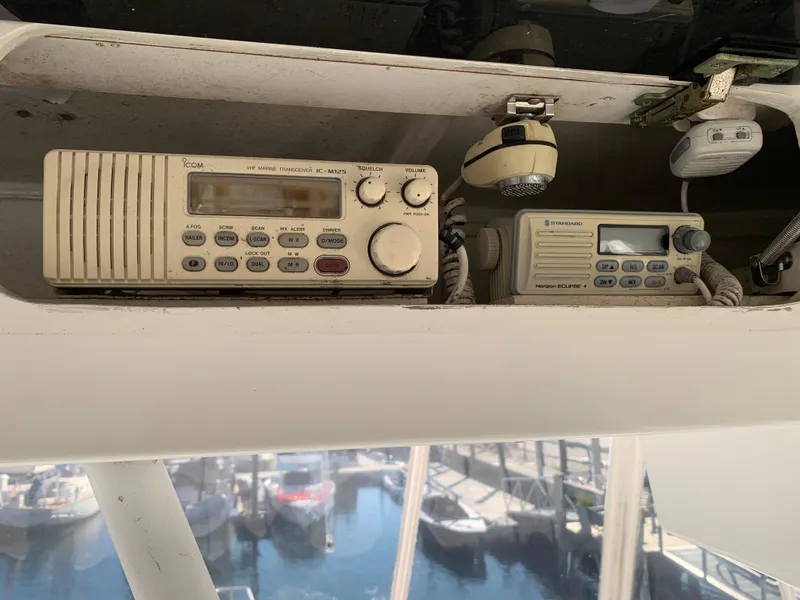 Slide: The Image of VHF marine radios on a 1997 Phoenix 38 SFX Convertible boat, docked at a marina. - 32