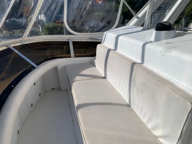Slide: The Image of 1997 Phoenix 38 SFX Convertible boat interior with white cushioned seating and clear windows. - 34