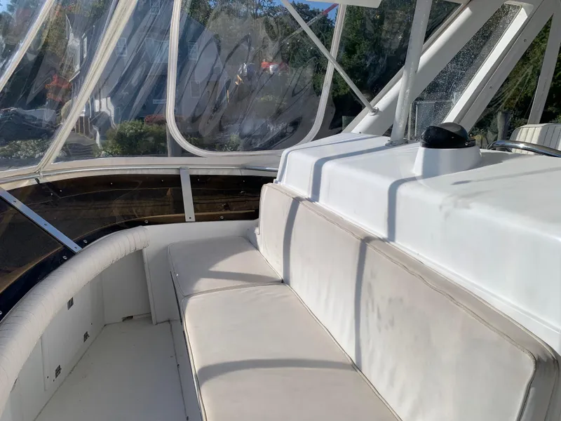 Slide: The Image of Interior of 1997 Phoenix 38 SFX Convertible boat with white seating and clear windows. - 35