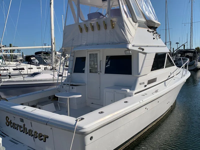 Slide: The Image of 1997 Phoenix 38 SFX Convertible yacht docked at marina, named "Starchaser." - 4