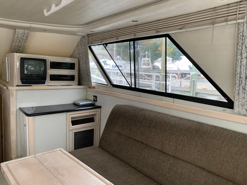 Slide: The Image of Interior of 1997 Phoenix 38 SFX Convertible yacht with sofa, TV, and large window. - 46