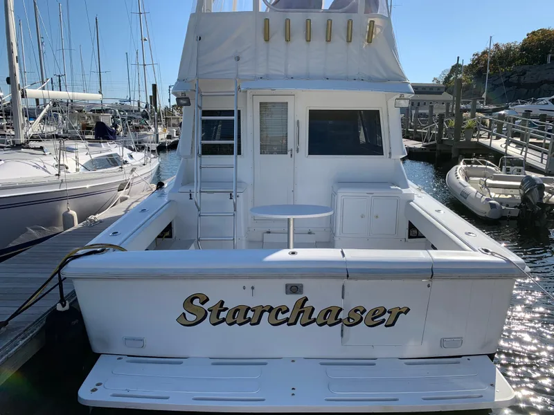 Slide: The Image of 1997 Phoenix 38 SFX Convertible boat named "Starchaser" docked at a marina. - 5