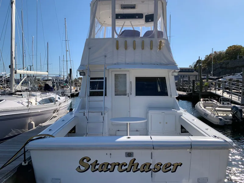 Slide: The Image of 1997 Phoenix 38 SFX Convertible boat named "Starchaser" docked at a marina. - 6