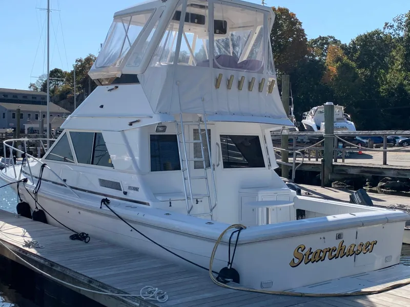 Slide: The Image of 1997 Phoenix 38 SFX Convertible boat named "Starchaser" docked at a marina. - 9